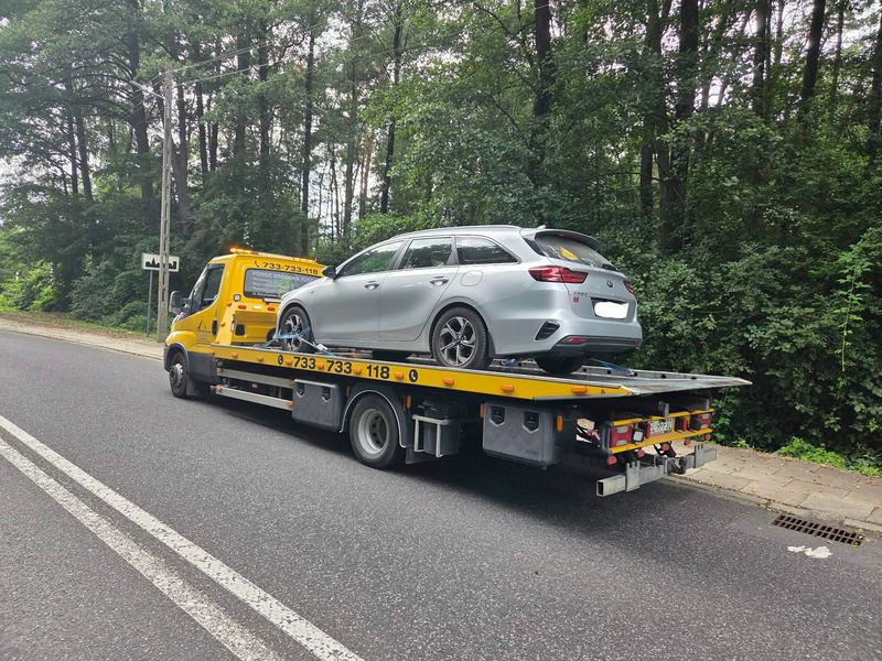 Kombi bez widocznych uszkodzeń wiezie laweta pomocy drogowej Tuszyn leśną drogą