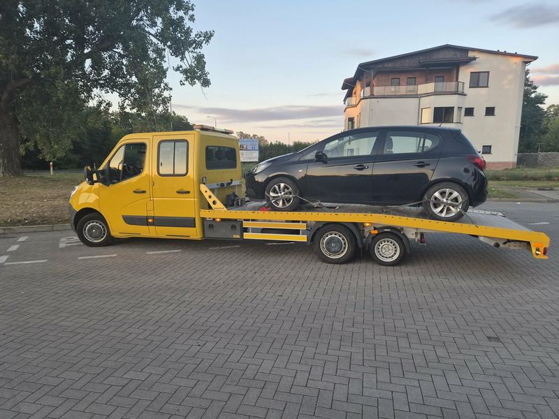 Hatchback bez uszkodzeń zabezpieczony na lawecie na osiedlowym parkingu o zmierzchu, pomoc drogowa Tuszyn
