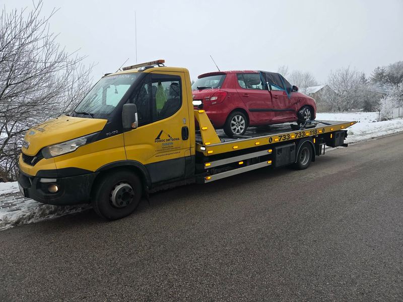 Laweta wiezie zimą hatchback z rozbitą tylną szybą, pomoc drogowa Tuszyn