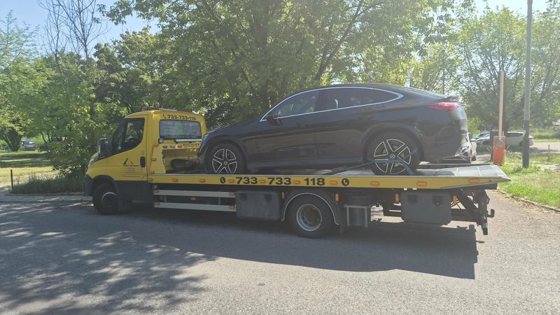 Sprawny samochód typu SUV coupe stojący na lawecie pomocy drogowej Tuszyn na słonecznym parkingu