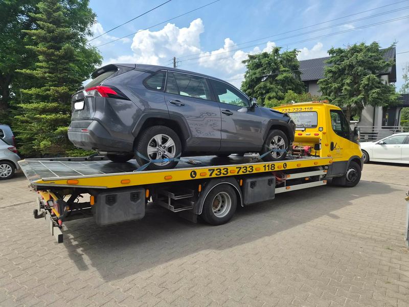 Laweta pomocy drogowej Tuszyn przewozi SUV-a zabranego z prywatnej posesji przy domu