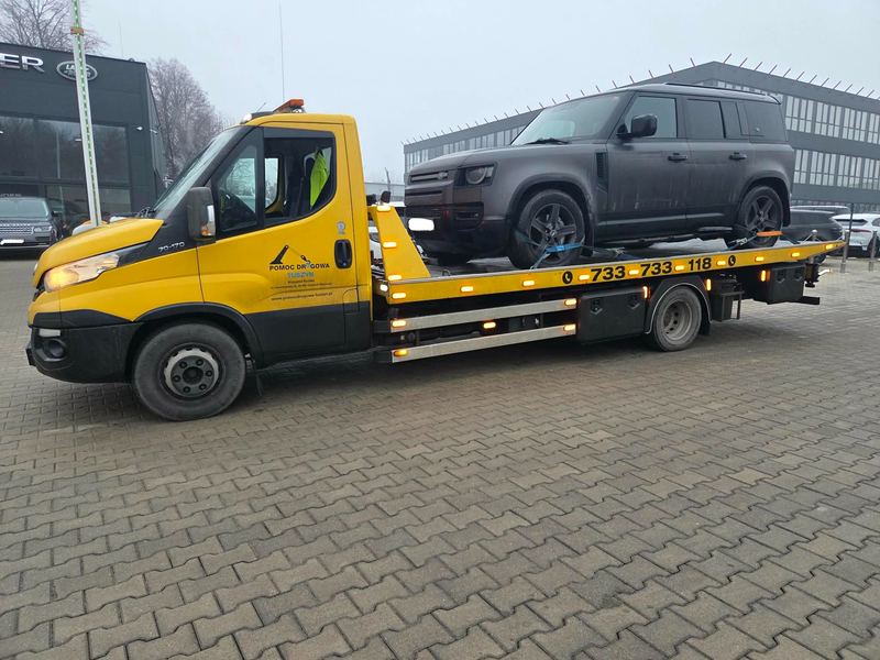 Pomoc drogowa Tuszyn przewozi lawetą nieuszkodzony pojazd terenowy SUV na placu przed salonem