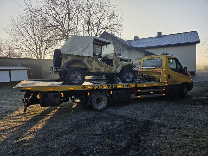 Laweta pomocy drogowej Tuszyn transportuje zabytkowy pojazd terenowy w mroźny poranek